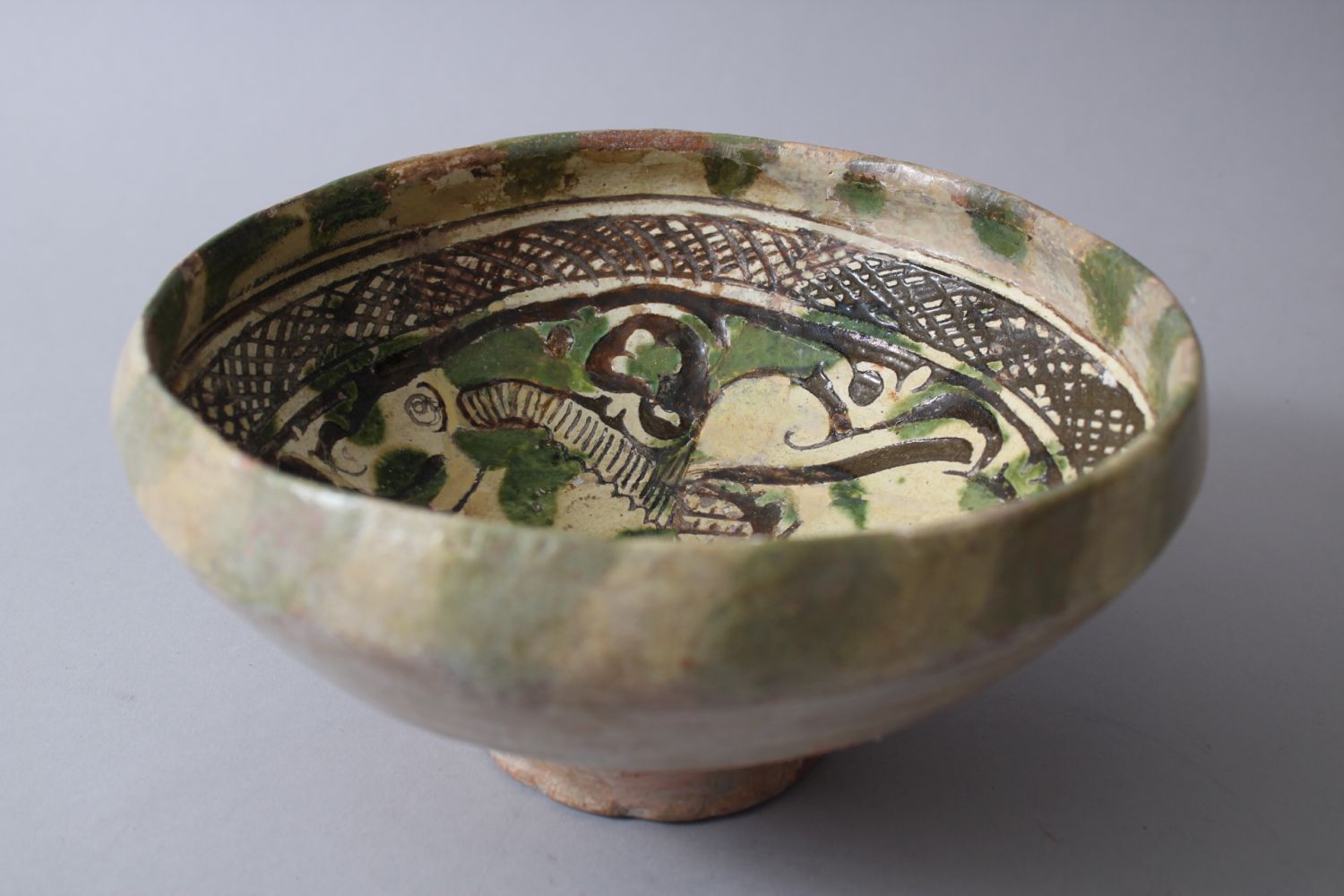 A 12TH-13TH CENTURY GARUS GLAZED POTTERY BOWL bearing a rams image amongst foliage. - Image 2 of 6