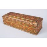 A 19TH CENTURY INDIAN KASHMIR LACQUERED INLAID LONG BOX AND COVER, 27cm long.