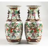A PAIR OF 19TH CENTURY CHINESE VASES with scenes of warriors and other figures. 17ins high.
