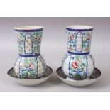TWO JAPANESE 19TH CENTURY PORCELAIN VASES & SAUCERS, decorated with floral patterns, the interior