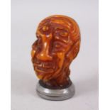 A CHINESE AMBER STYLE EROTIC SEAL IN THE FORM OF A HEAD, the head formed from a female's body, the