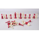 A SMALL ANGLO INDIAN RED AND WHITE IVORY CHESS SET in a wooden box.