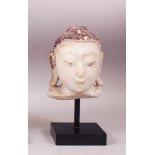 A SMALL 19TH CENTURY CARVED WHITE MARBLE BURMESE BUDDHA HEAD with painted headdress, on a pedestal