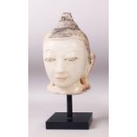 A 19TH CENTURY CARVED WHITE MARBLE BURMESE BUDDHA HEAD with painted headdress, on a pedestal base.