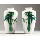 A GOOD PAIR OF JAPANESE WHITE GROUND CLOISONNE ENAMEL VASES with coloured bamboo. 7.5ins high.