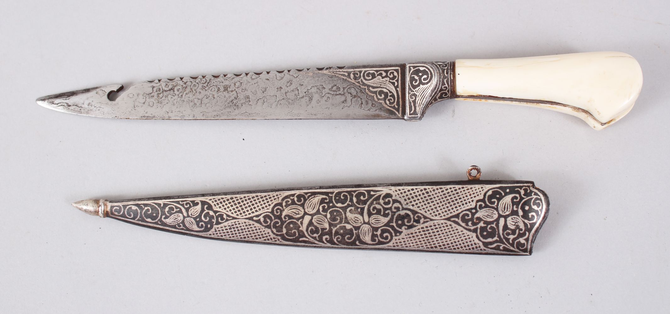 A 19TH CENTURY INDIAN DAGGER with ivory handle and silver inlaid sheath, 25cm long.