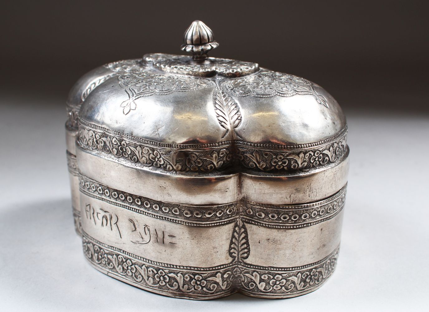 AN 18TH CENTURY MUGHAL INDIAN SILVER SHAPED BOX AND COVER, inscription on the front, 13cm long,