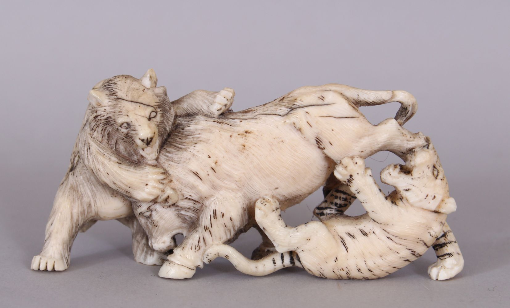 A JAPANESE MEIJI PERIOD IVORY OKIMONO OF A BEAR & A TIGER ATTACKING A BOAR, the details