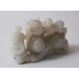 A GOOD CHINESE CARVED JADE / HARDSTONE PEN OR BRUSH HOLDER, carved in the form of a lion dog with