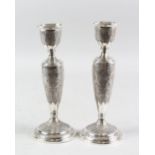 A PAIR OF PERSIAN WHITE METAL CANDLESTICKS, 19cm high.