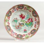 AN 18TH CENTURY CHINESE FAMILLE ROSE PLATE. 9ins diameter.