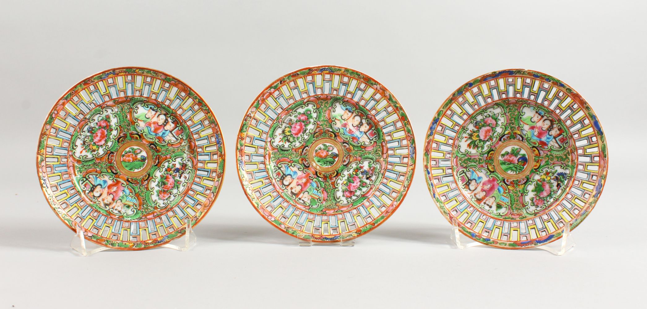 A SET OF THREE CANTON CIRCULAR PLATES pierced, with flowers. 6ins diameter.