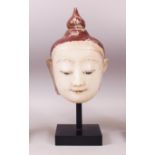 A 19TH CENTURY CARVED WHITE MARBLE BURMESE BUDDHA HEAD with painted headdress, on a pedestal base.