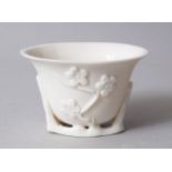 A CHINESE BLAN DE CHINE PORCELAIN LIBATION CUP, with moulded decoration of cherry blossom, 5.5cm