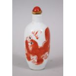 A 19TH / 20TH CENTURY CHINESE IRON RED LION DOG PORCELAIN SNUFF BOTTLE, the bottle with a red