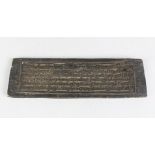 A 19TH CENTURY INDIAN OR TIBETAN WOODEN PRINTING BLOCK with calligraphy on each side, 33cm long,