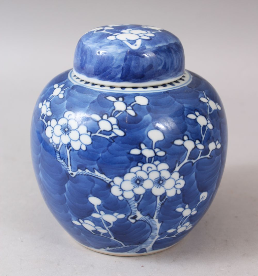 A SMALL 19TH CENTURY CHINESE BLUE AND WHITE PRUNUS PATTERN GINGER JAR AND COVER, 14cm high.