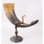 A 19TH CENTURY INDIAN CARVED DRINKING HORN ON A STAND with Nandi bull finial.