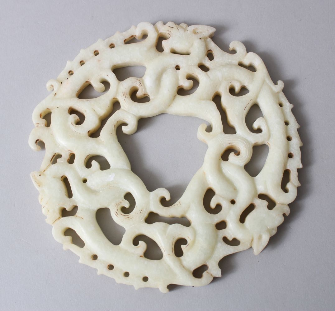 A GOOD CHINESE 19TH / 20TH CENTURY CARVED WHITE JADE ROUNDEL / BI DISK, carved to depict intertwined