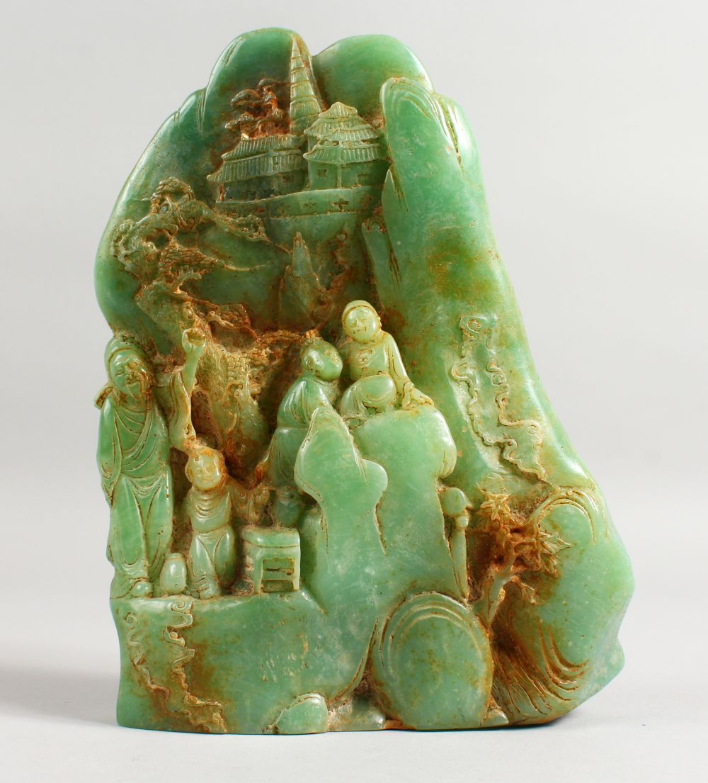 A CARVED GREEN STONE GROUP with four figures. 8.5ins high.