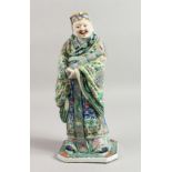 A VERY GOOD CHINESE FAMILLE ROSE STANDING FIGURE OF A MAN carrying a scroll. 13INS HIGH.