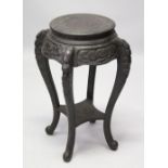 A CHINESE EBONISED SOFTWOOD STAND, circular top on four curving legs united by an undertier, 35cm