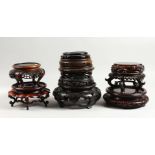 A BOX OF TEN MEDIUM AND SMALL CHINESE CARVED WOOD VASE STANDS.