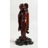 A CHINESE CARVED WOOD FIGURE OF A BOY. 7ins high.