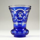 A BOHEMIAN BLUE TINTED THISTLE SHAPED BEAKER-VASE with plain base. 5.5ins high.