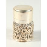 A VICTORIAN GLASS SCENT BOTTLE with plain silver top and glass stopper in a pierced filigree