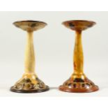 A PAIR OF ROYAL DOULTON STONEWARE ART NOUVEAU CANDLESTICKS, the circular bases decorated with