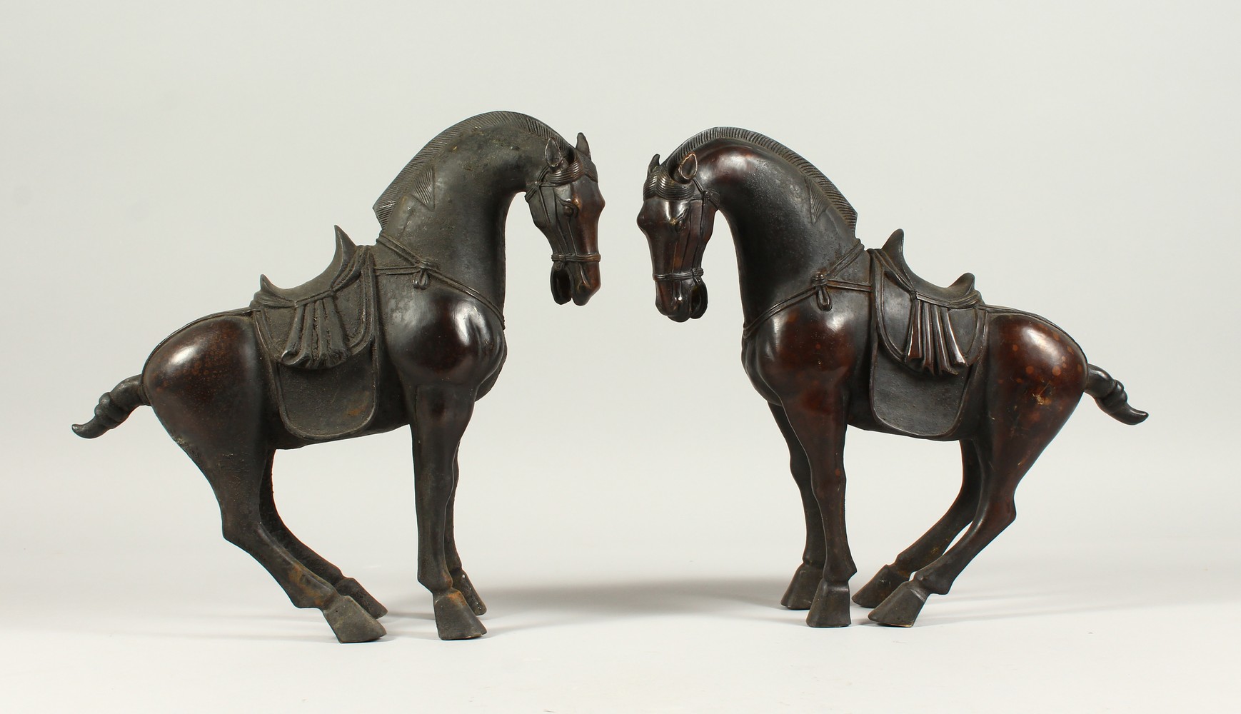 A PAIR OF BRONZE TANG STYE STANDING HORSES. 29cms high.