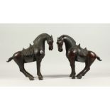 A PAIR OF BRONZE TANG STYE STANDING HORSES. 29cms high.