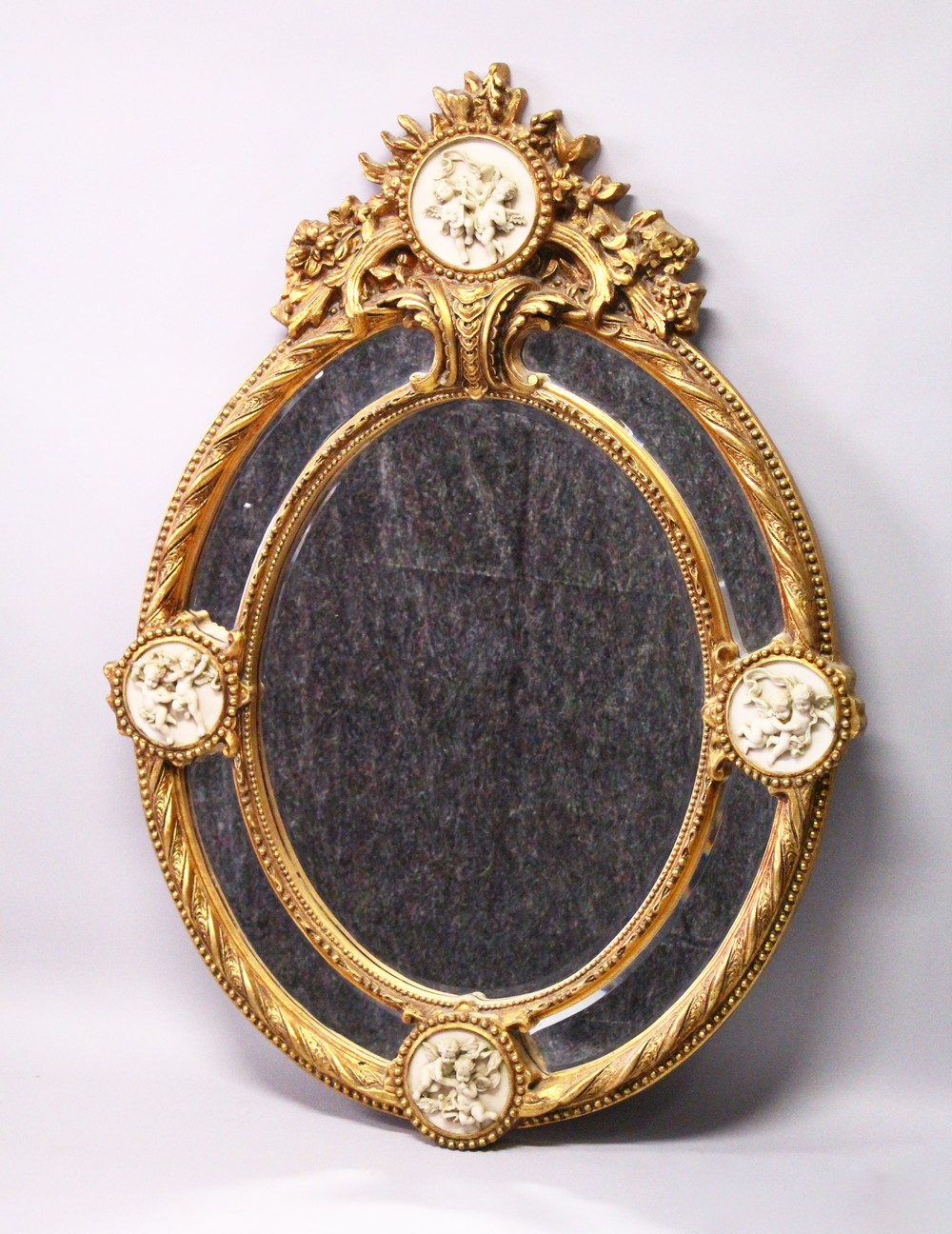 A DECORATIVE, LARGE OVAL FRENCH STYLE GILT FRAMED MIRROR, 20TH CENTURY, with mirrored slips and four