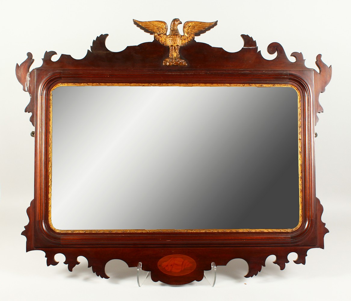 A GEORGIAN STYLE MAHOGANY FRETWORK FRAMED MIRROR, with shell inlay and eagle finial. 80cms high x