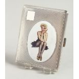 AN ENGINE TURNED CIGARETTE CASE, with an enamel oval of a glamour model in a black dress. Birmingham