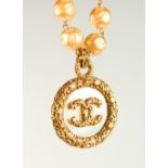 A LARGE PEARL NECKLACE, with Chanel logo pendant, in original ribbon bound box.