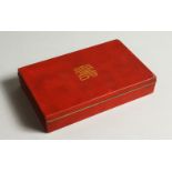 A JAPANESE RED ENAMEL DECORATED GILT METAL BOX. 13.5cms wide.