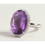 A LARGE SILVER OVAL AMETHYST RING.