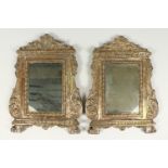 A PAIR OF ITALIAN METAL UPRIGHT MIRRORS, with scroll decoration and claw feet. 15ins high x 11.