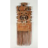 A TRIBAL CARVED WOOD COMB, monkey on an elephant. 41cms high.