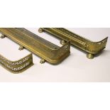 THREE 19TH CENTURY PIERCED BRASS FENDERS. 108cms long, 104cms long and 94cms long.