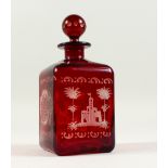 A BOHEMIAN SQUARE SHAPE RUBY GLASS DECANTER, engraved with a castle and a deer. 19cms high.