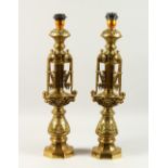 A PAIR OF 20TH CENTURY ORNATE CAST BRASS TABLE LAMPS. 60cms high.