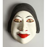 A CARVED AND PAINTED WOOD MASK OF A WOMAN. 20.5cms high.