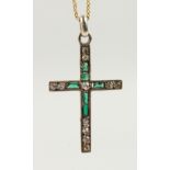 AN 18CT GOLD, DIAMOND AND EMERALD CROSS on a chain.