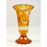 A LARGE BOHEMIAN AMBER VASE, etched with deer in a woodland setting. 10.5ins high.
