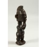 A SMALL CARVED WOOD TRIBAL FIGURE of a man with his hands in his mouth. 18.5cms high.