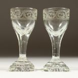 A PAIR OF GEORGIAN ENGRAVED WINE GLASSES on square bases.