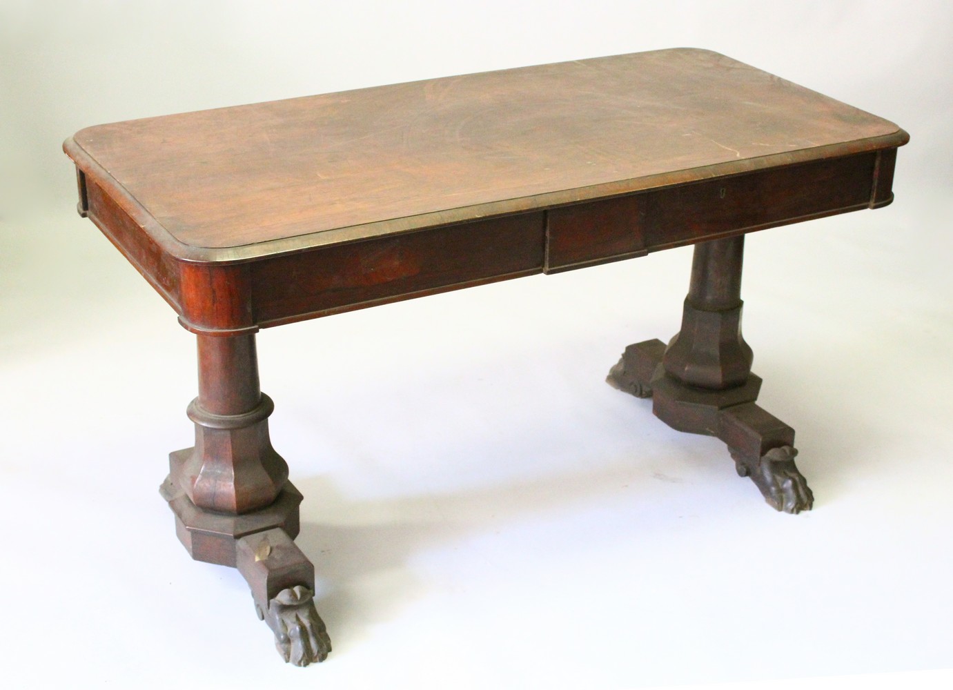 A REGENCY ROSEWOOD LIBRARY TABLE, with rounded rectangular top, the frieze drawers on turned